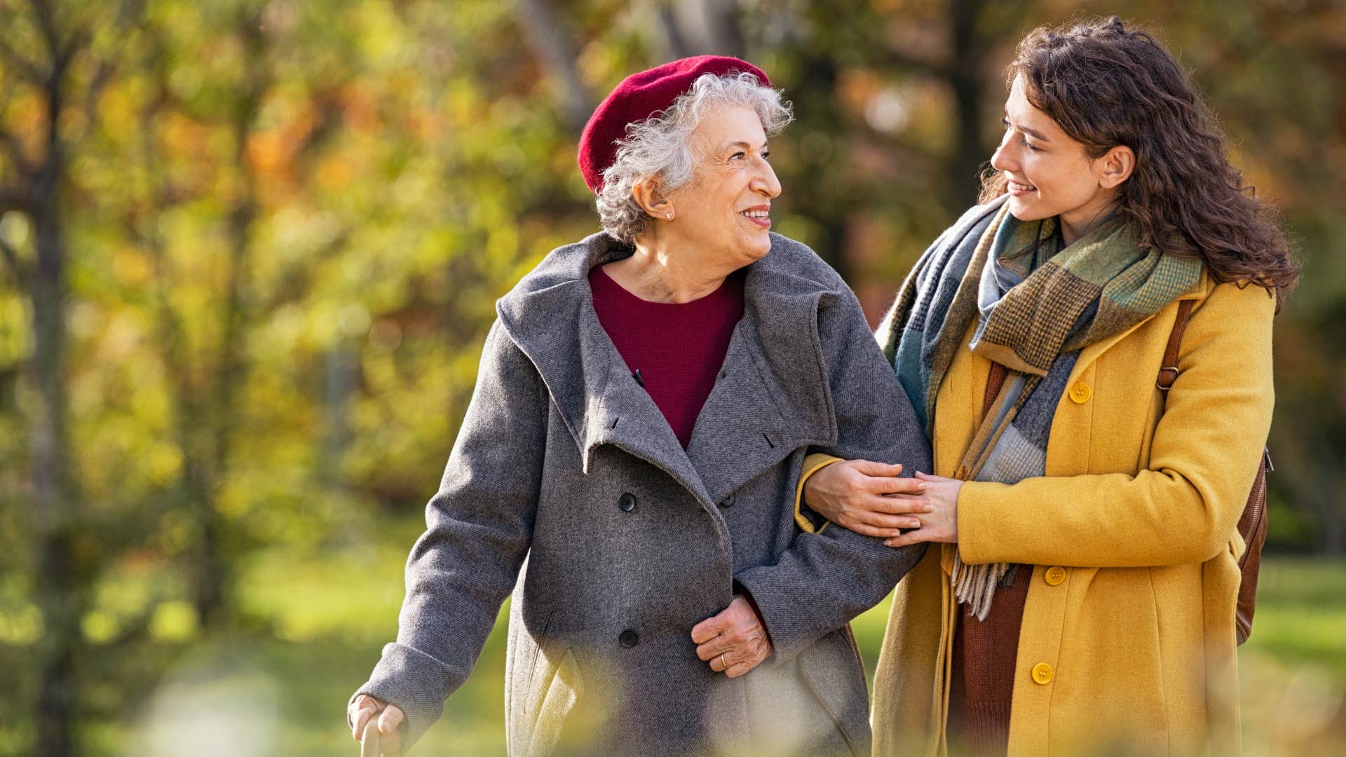 Young woman helping older woman walk 