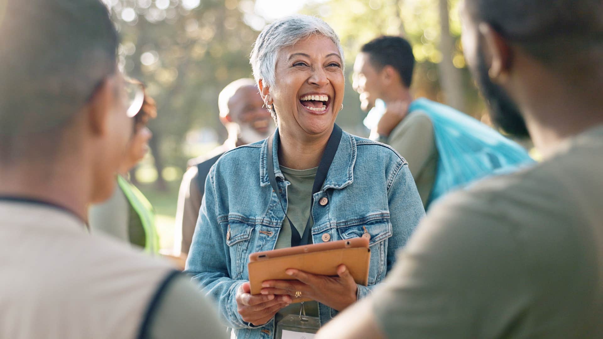 Older woman smiling while talking to two men