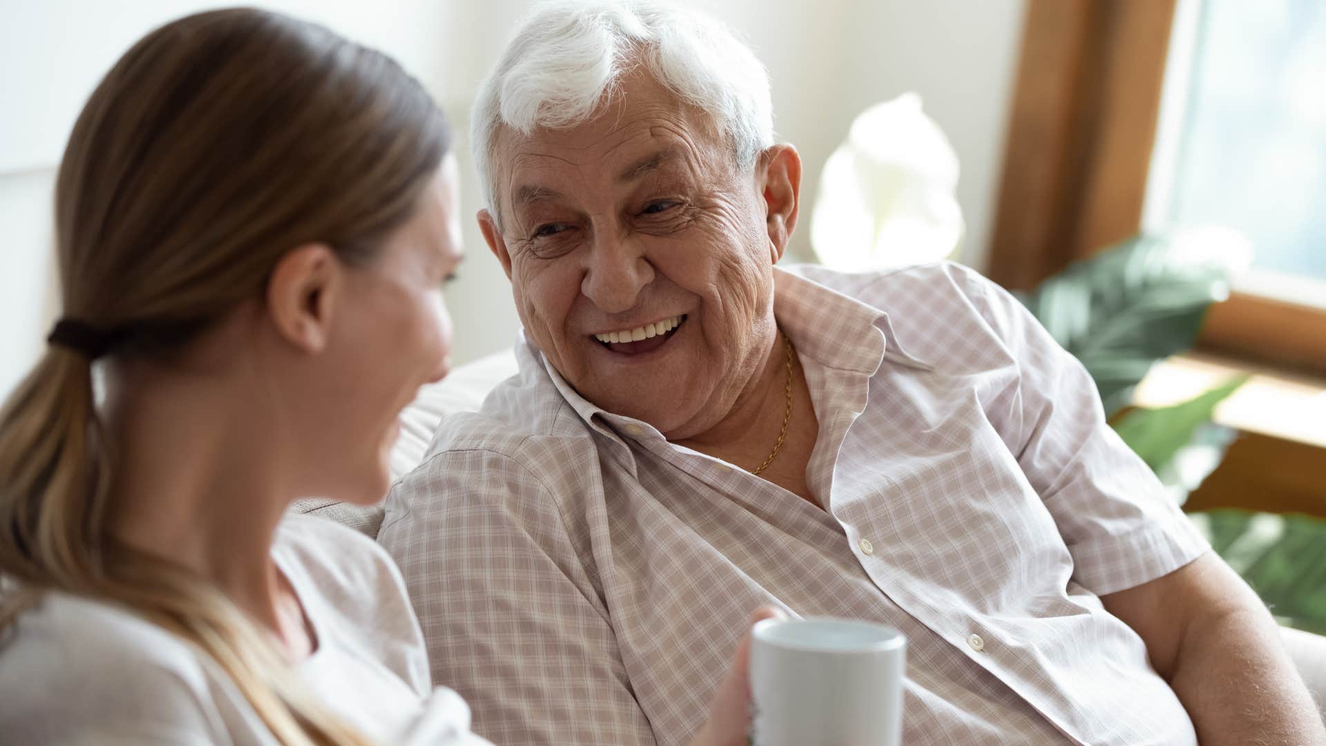 Dad talking to his adult daughter on the couch