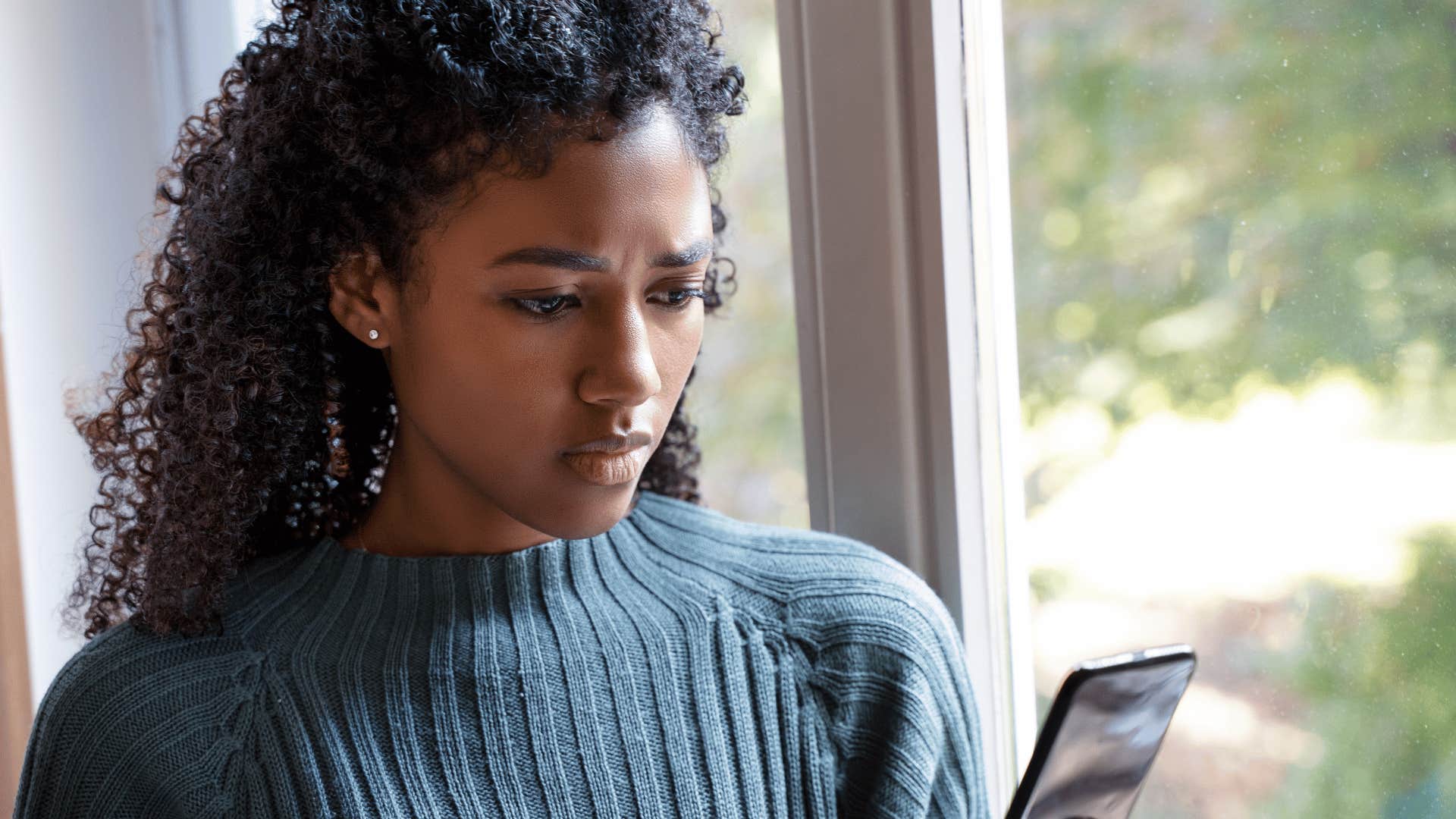 Woman feels jealous while looking at phone