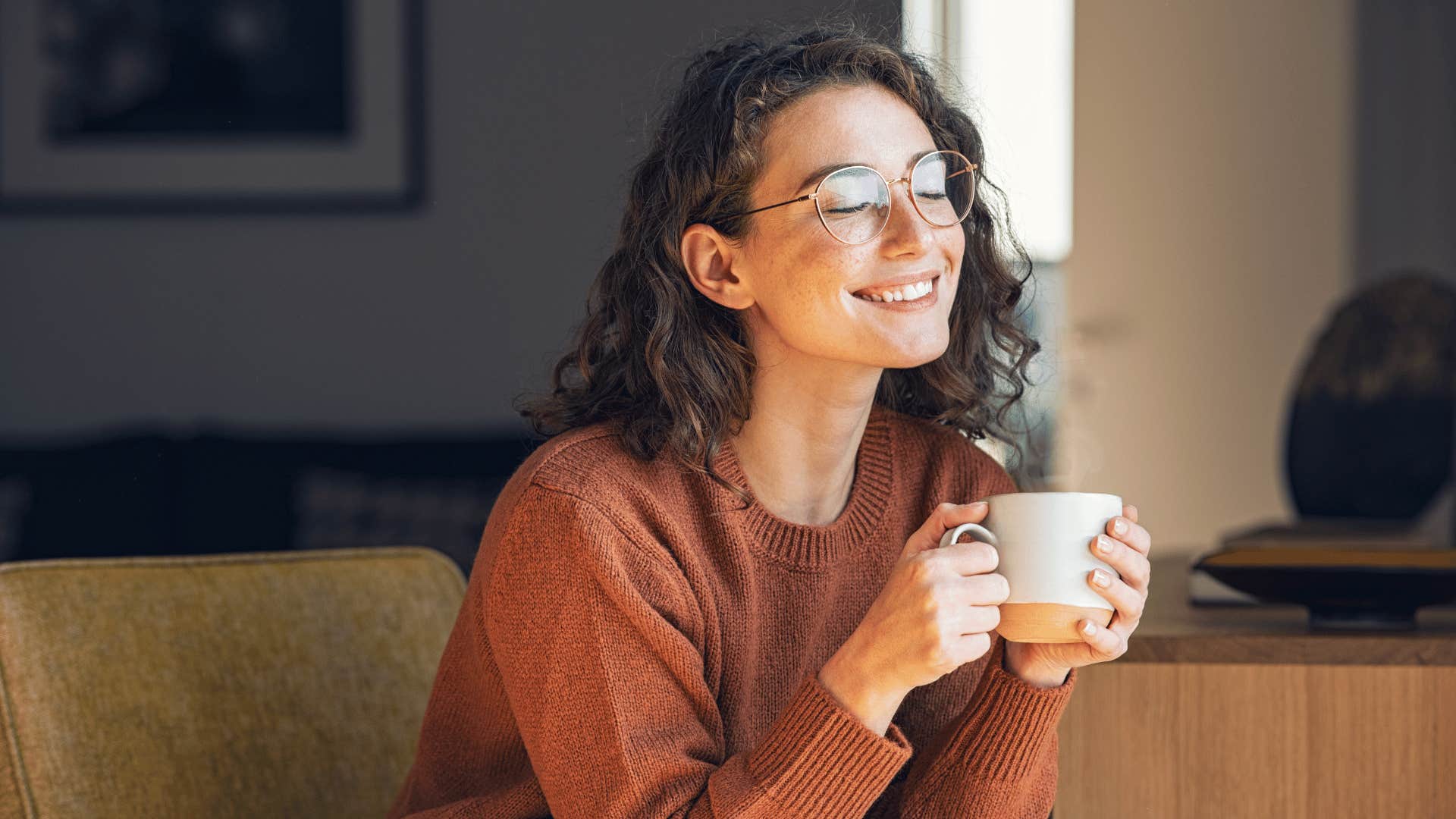 woman sipping coffee and smiling