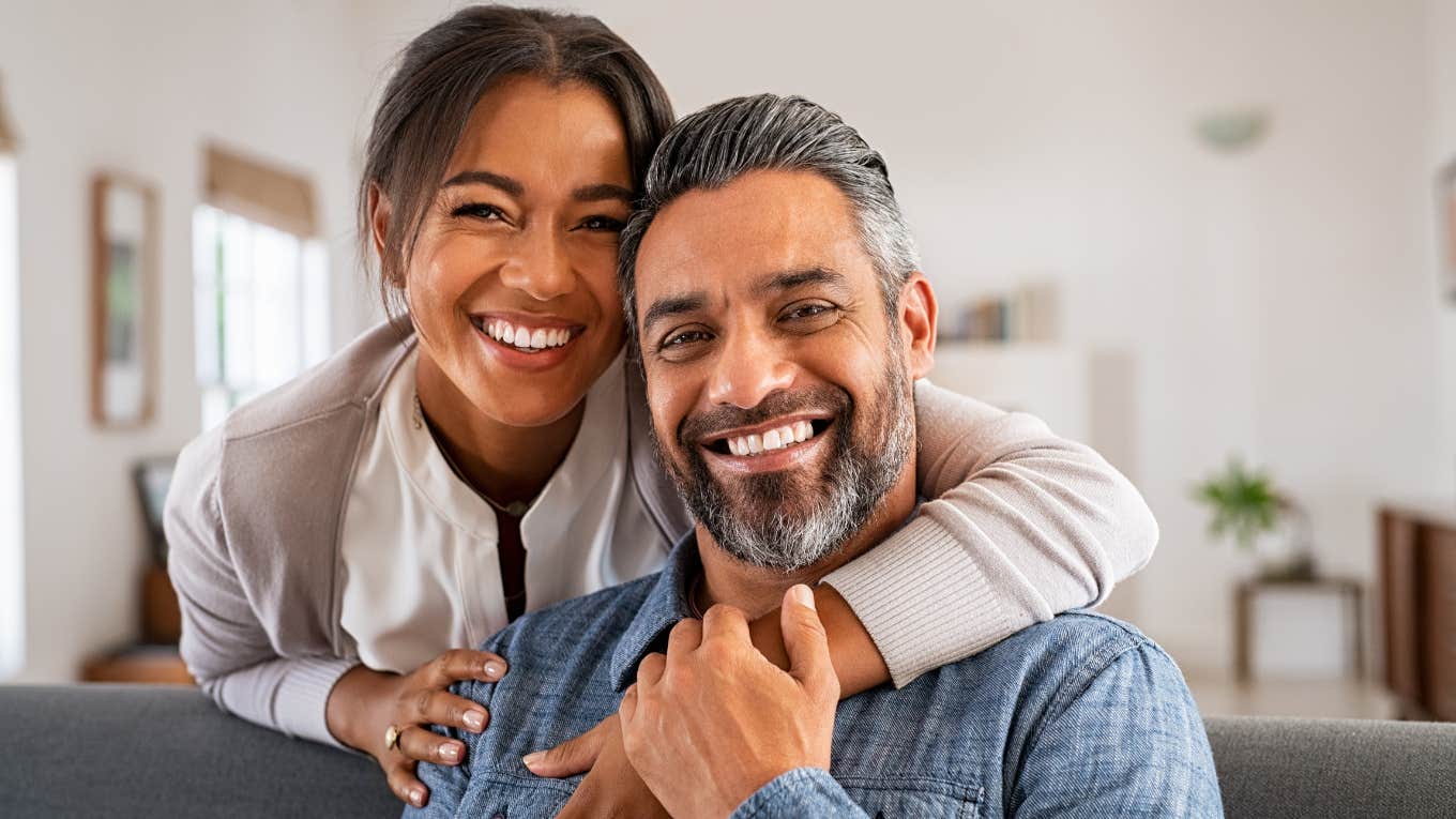 couple smiling together sitting on couch