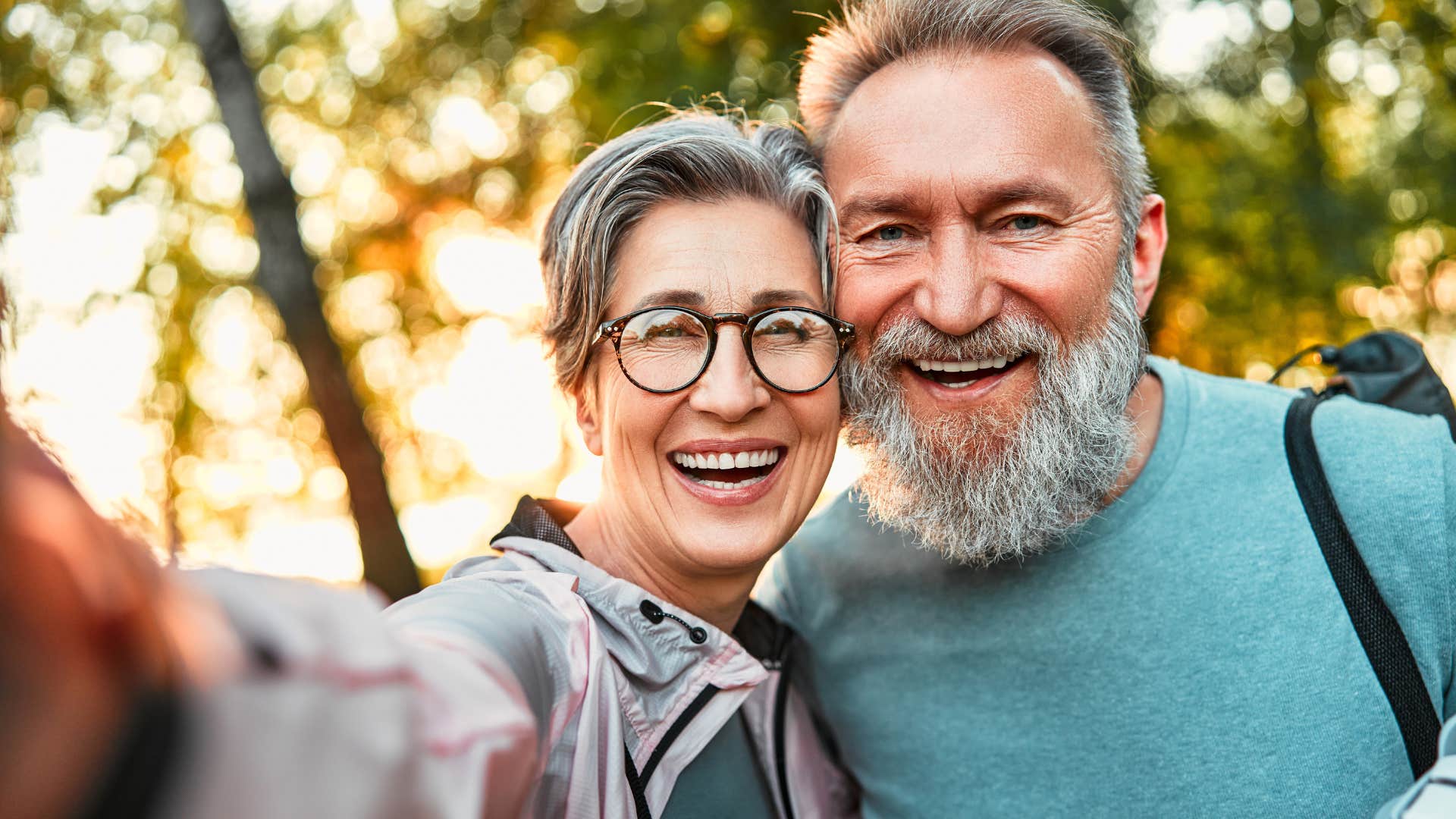 Older couple smiling and taking a picture.