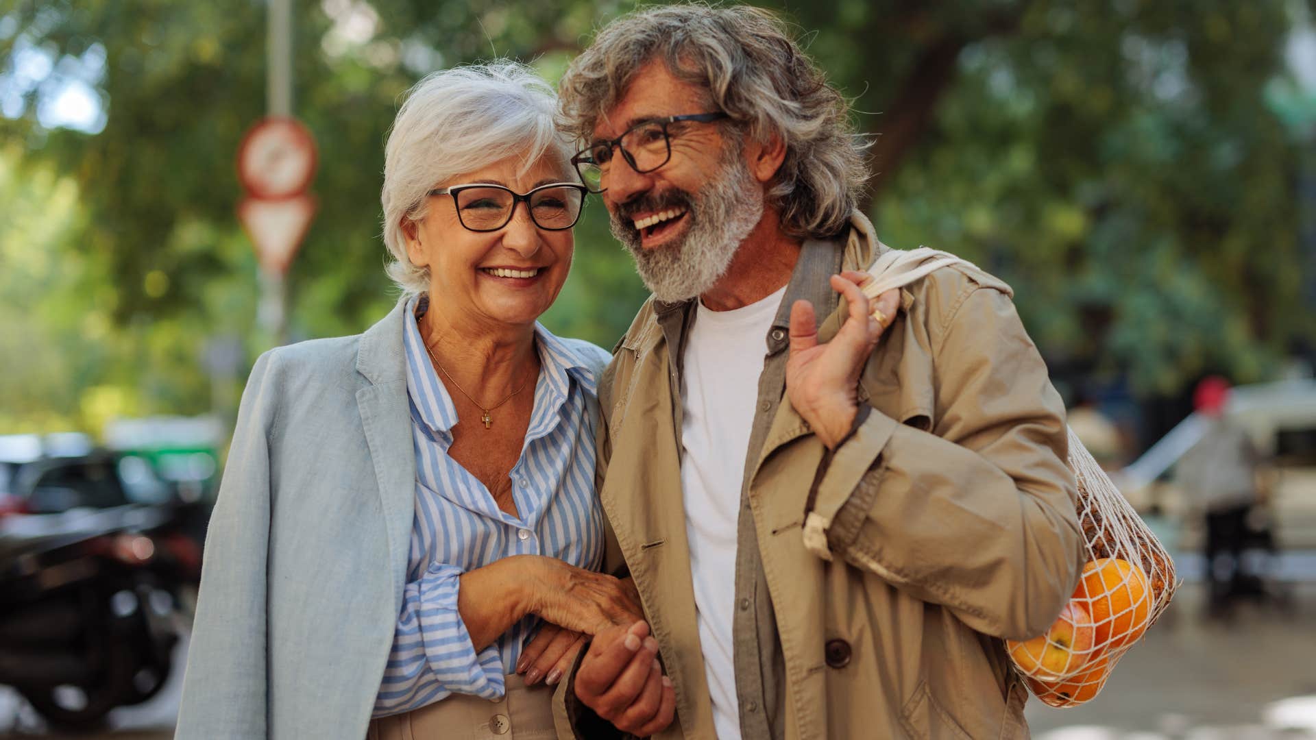 Older couple smiling and walking together outside.