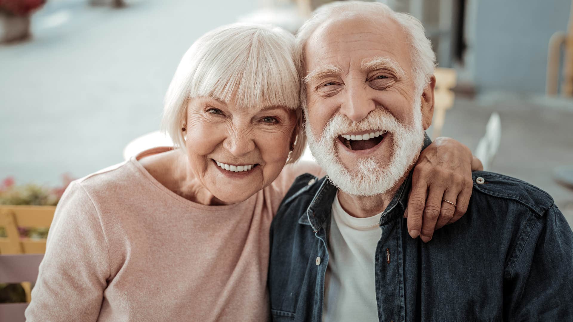 Older couple smiling and hugging each other.