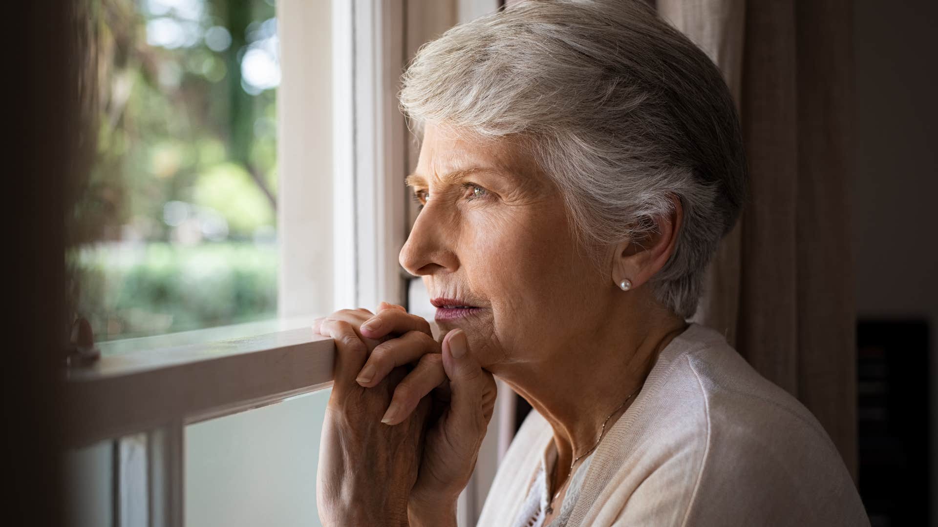 Older woman looking out a window