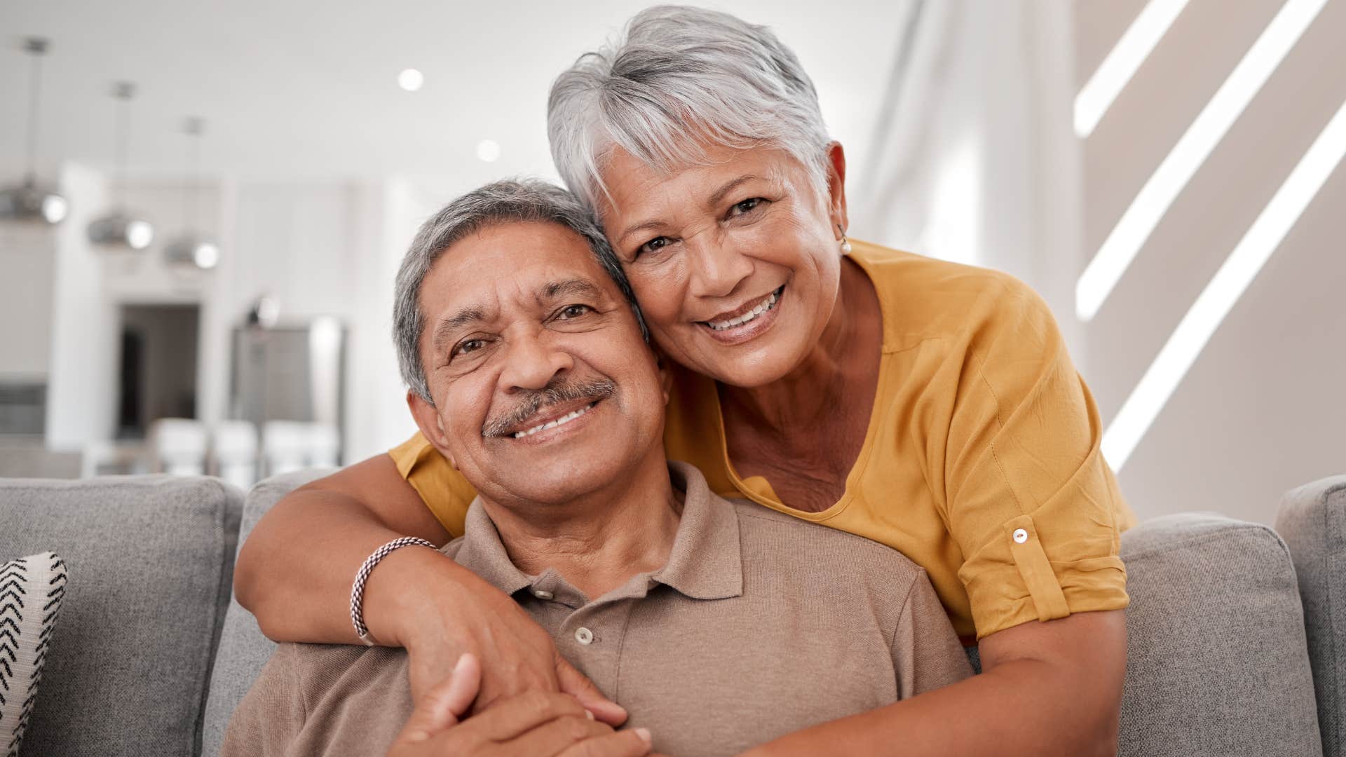 Older couple smiling and hugging each other.