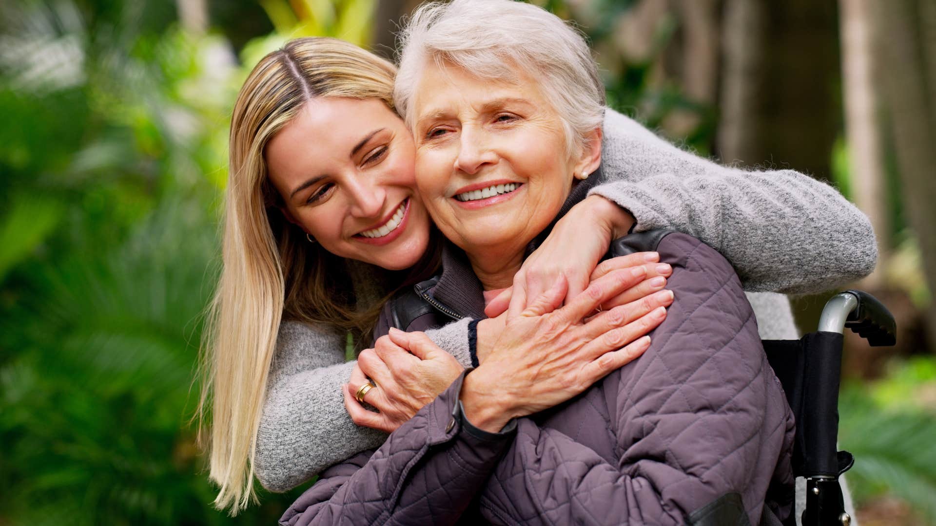 Adult woman hugging her mother outside.