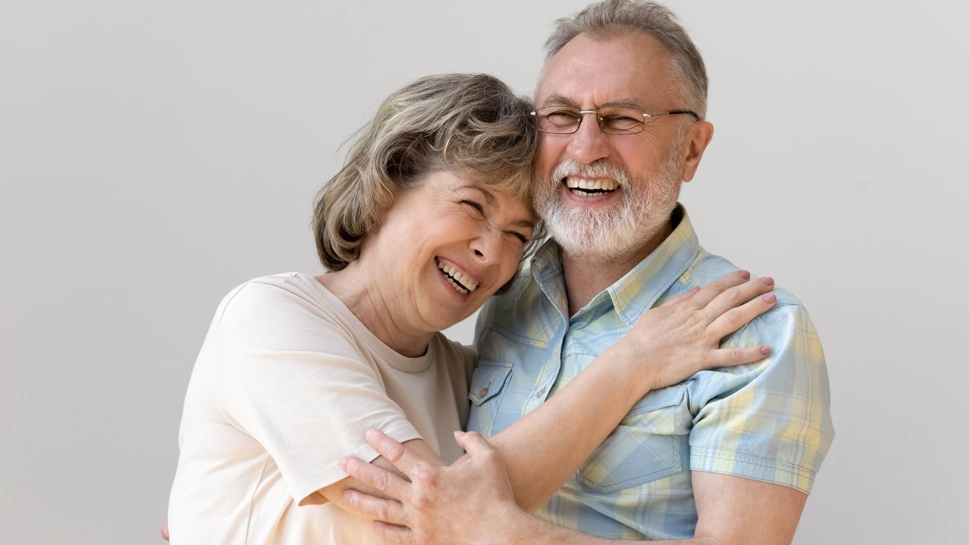 Older couple smiling and looking at the camera.