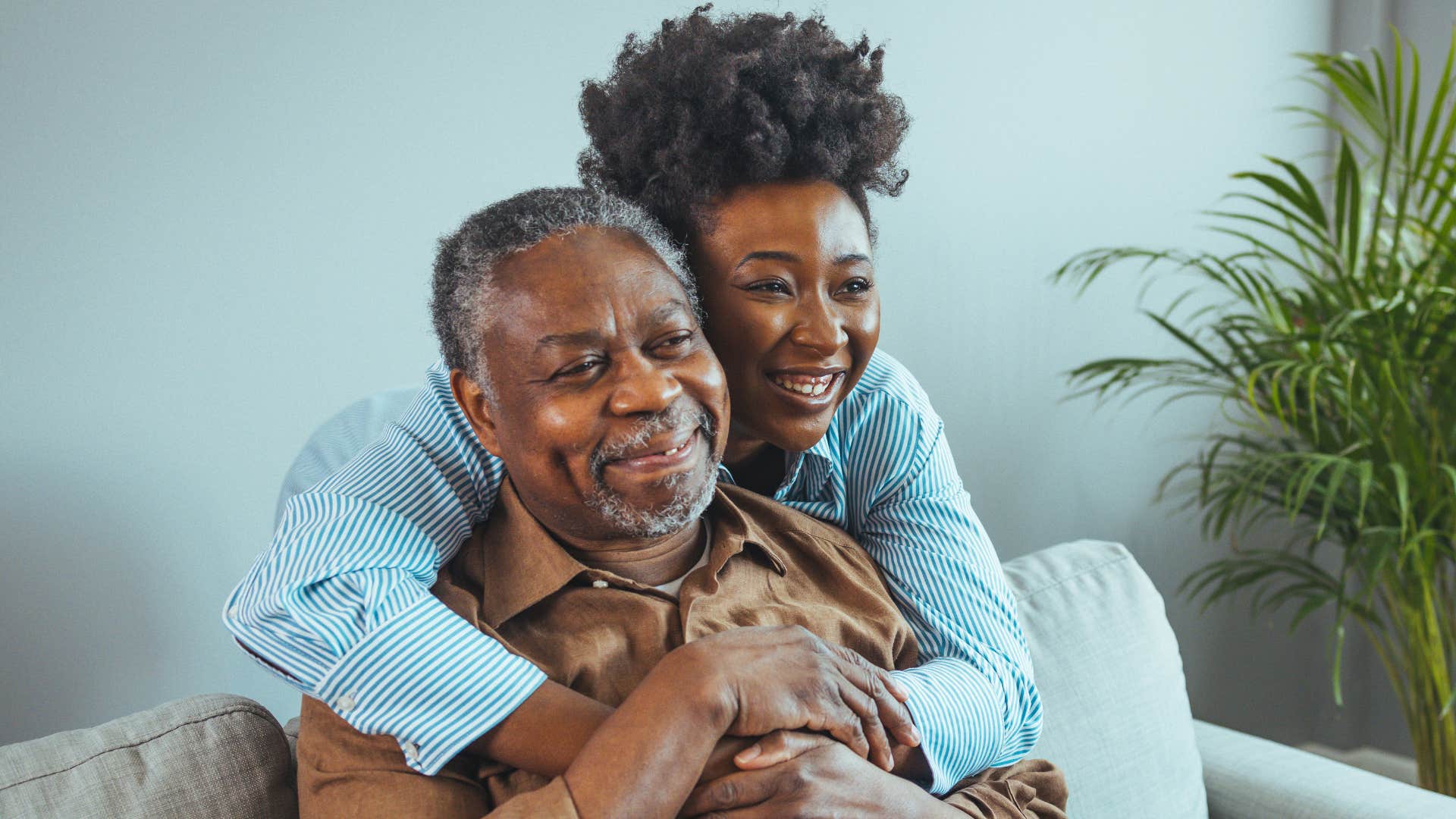 Adult daughter smiling and hugging her dad.