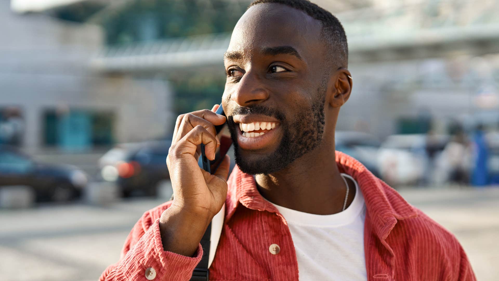 Man smiling while talking on the phone.