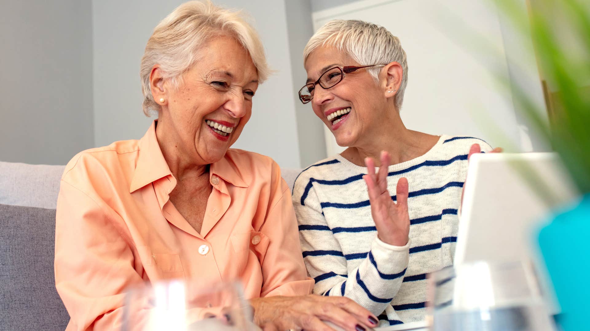 Two older women smiling and laughing together.