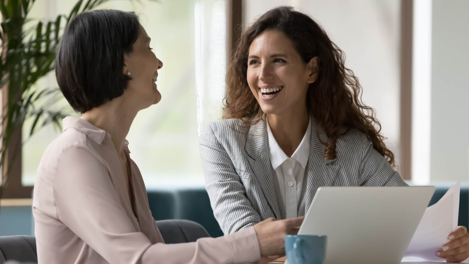 Two co-workers smiling and laughing together.