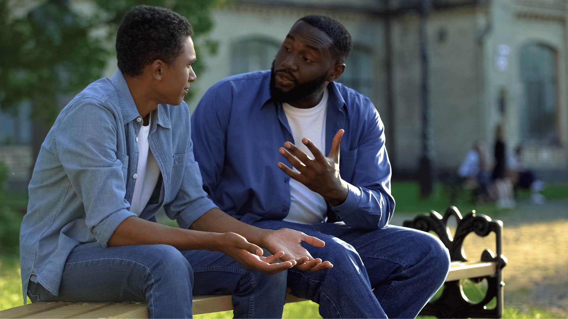 son and father arguing on bench