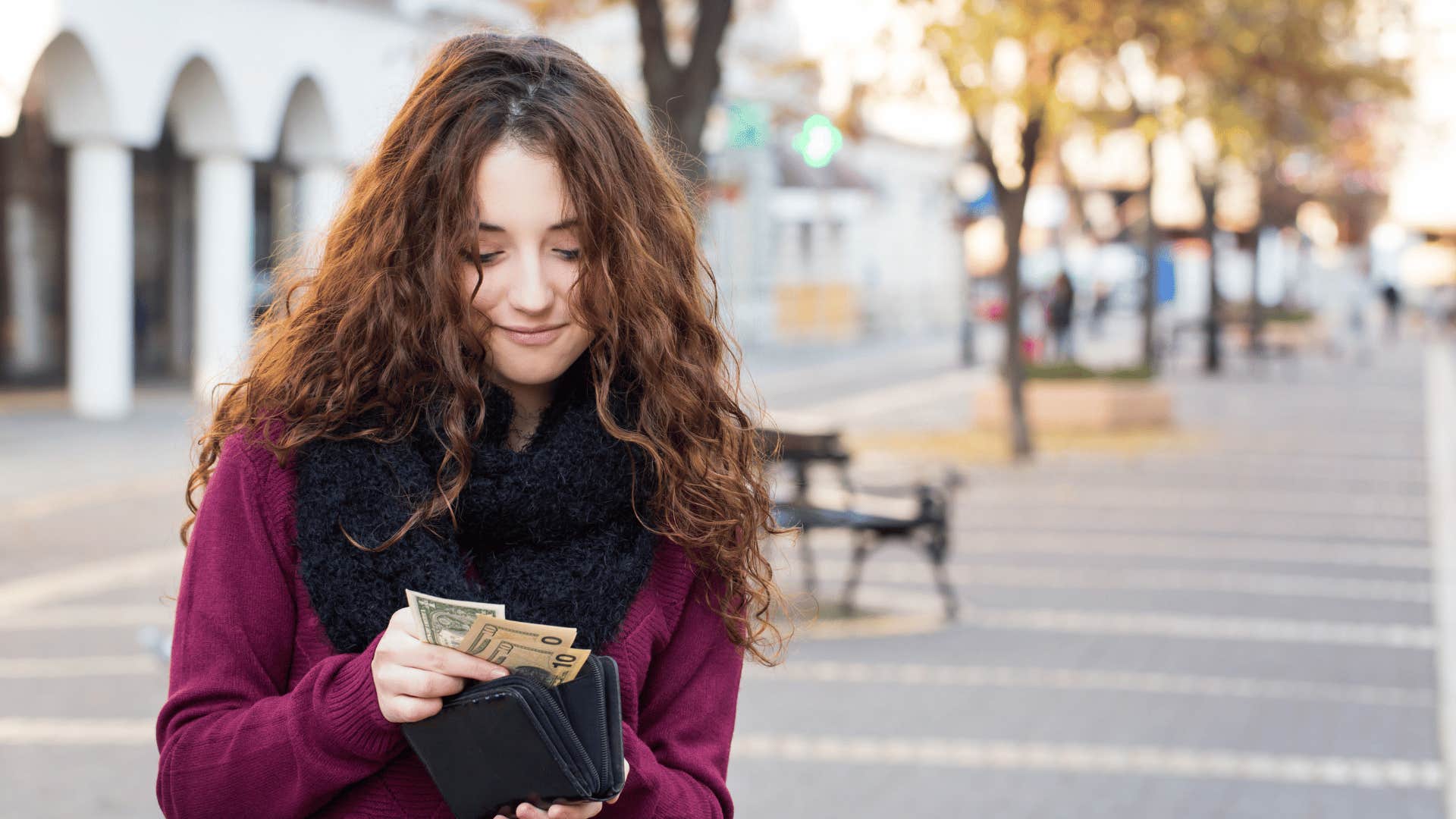 young woman looking through her wallet