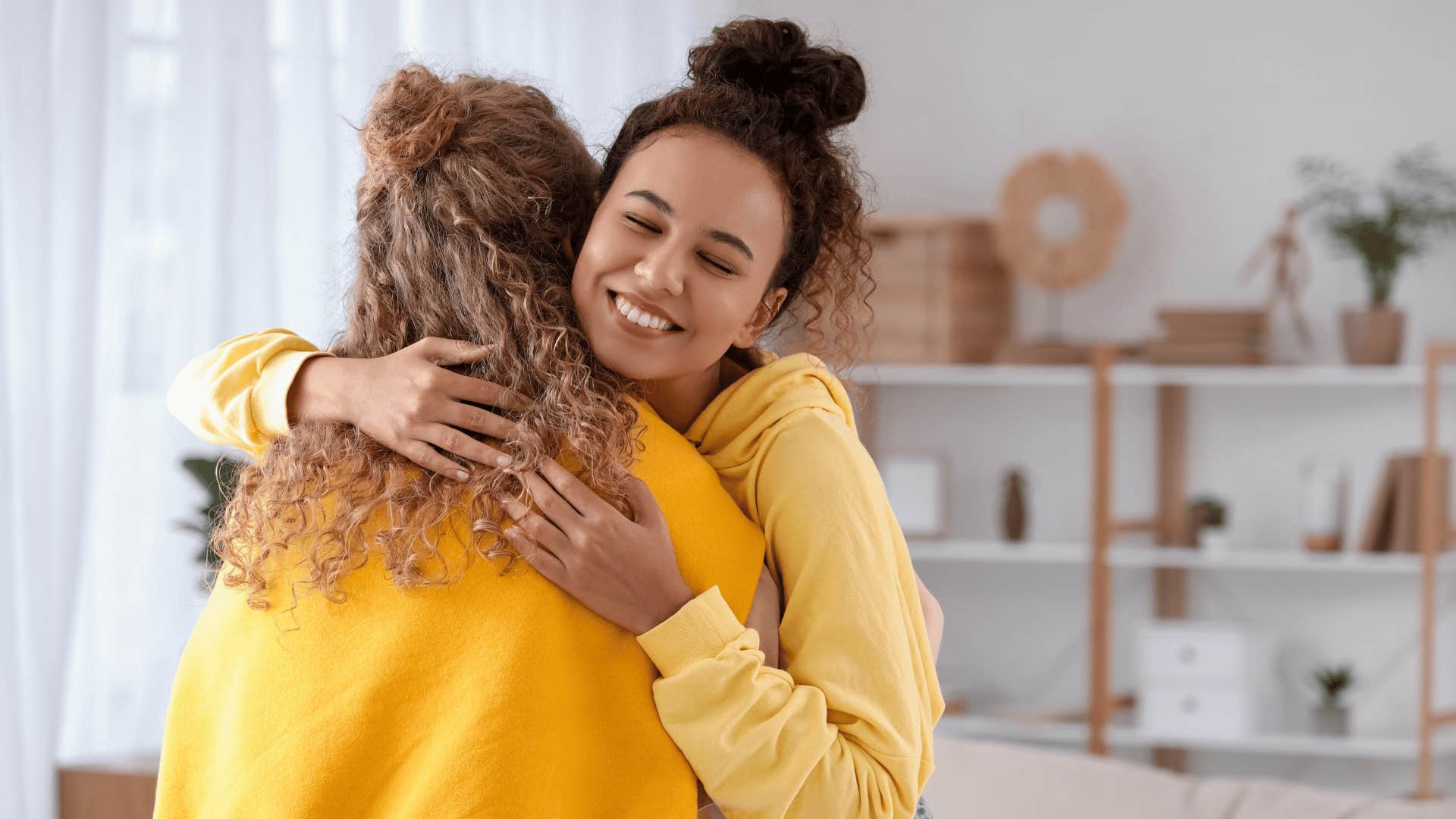 two friends hugging and smiling 