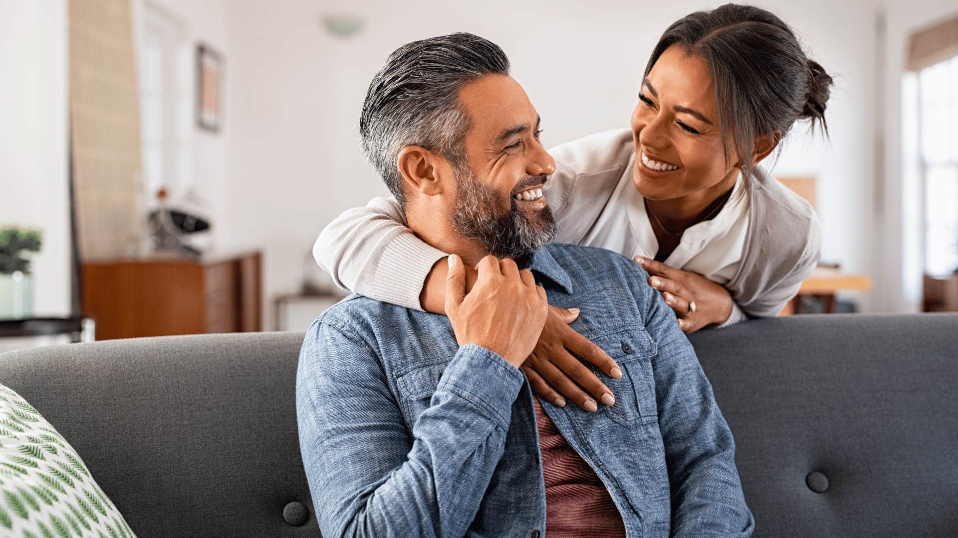 woman holding onto man and laughing