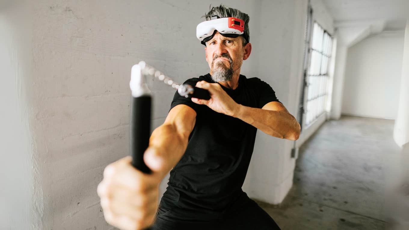 Man wearing mask, playing with nunchucks.