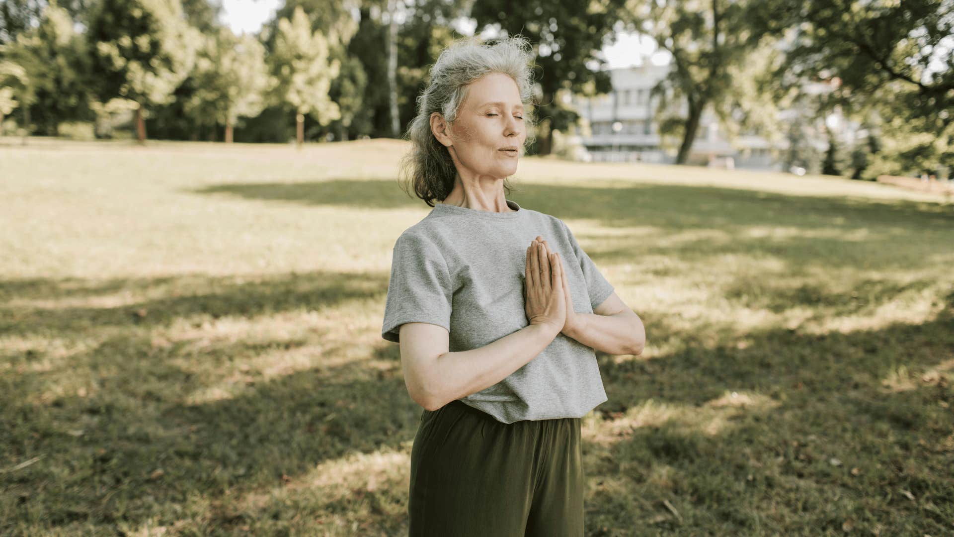 woman taking a deep breath in a park