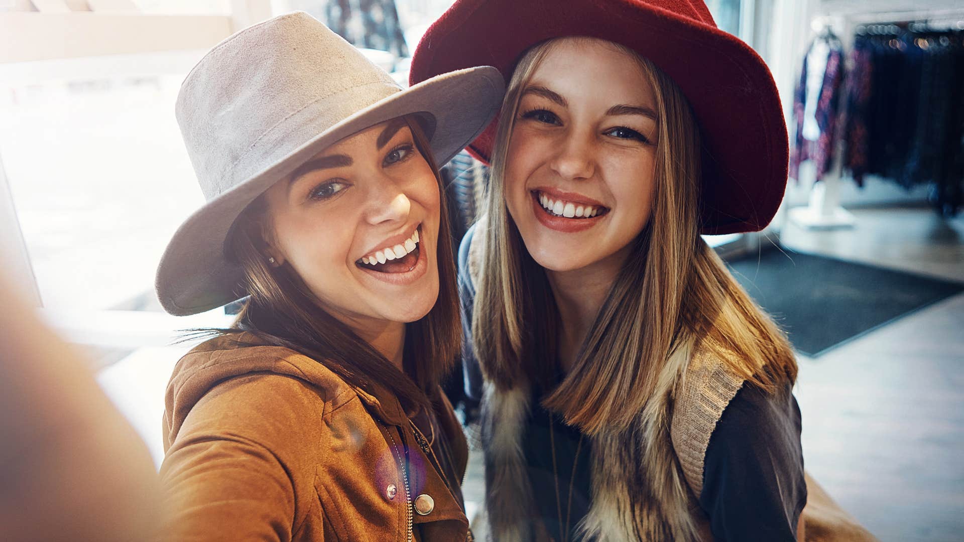 Two women wearing hats smiling at the camera.