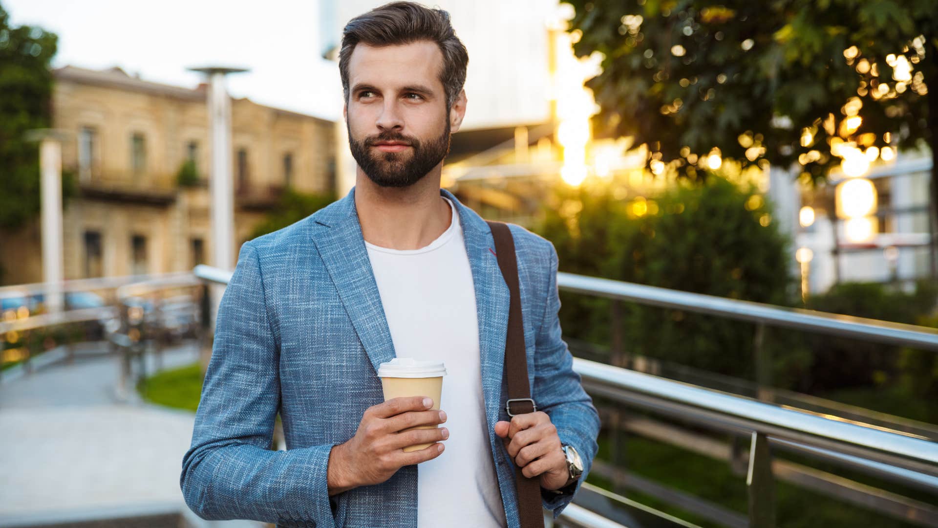 Young man in a suit walking outside.