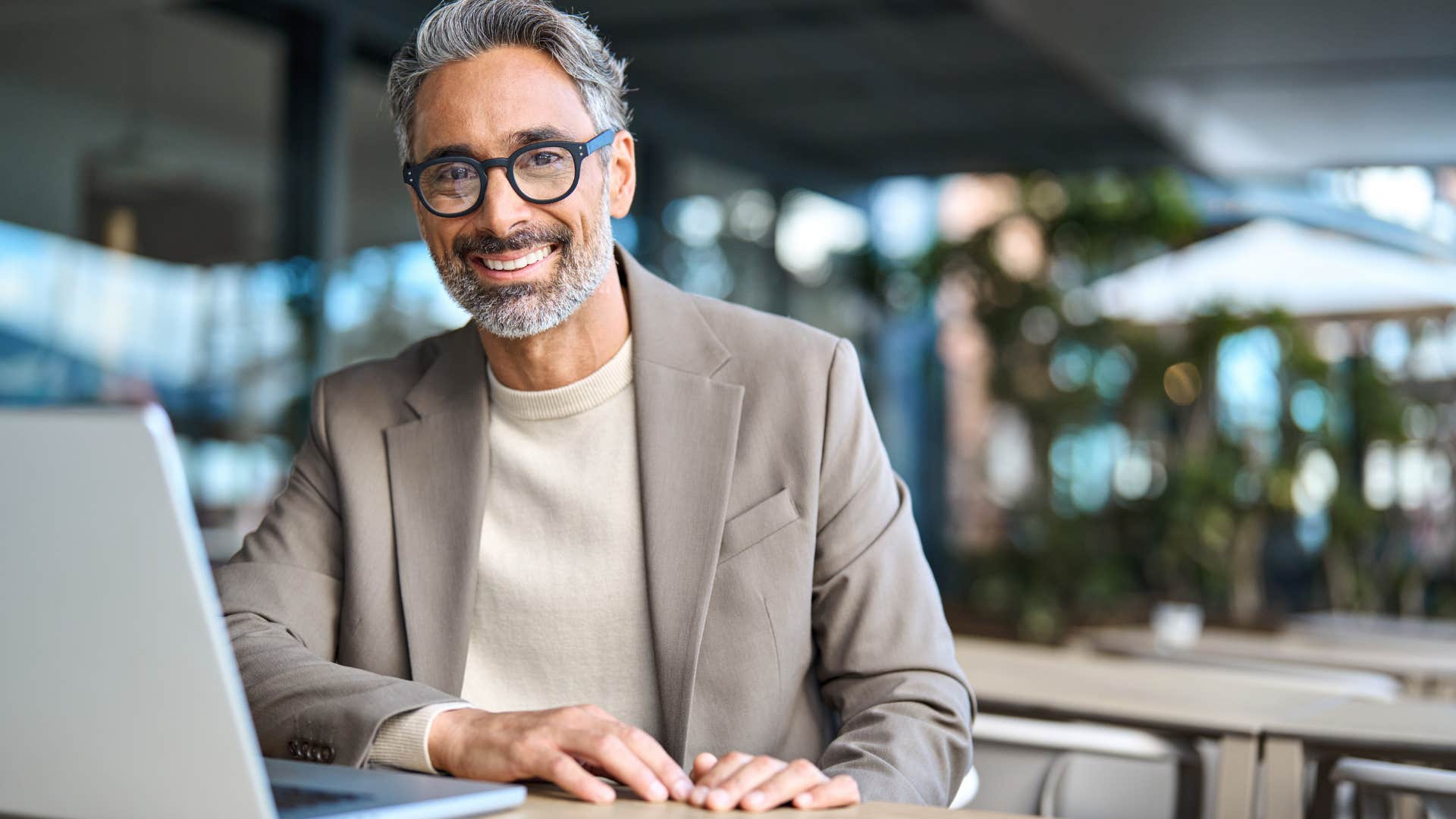 Older man smiling and sitting at work.