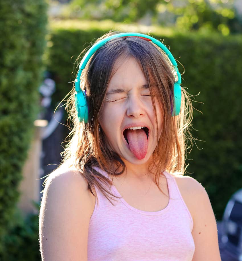 Girl wearing headphones makes silly face