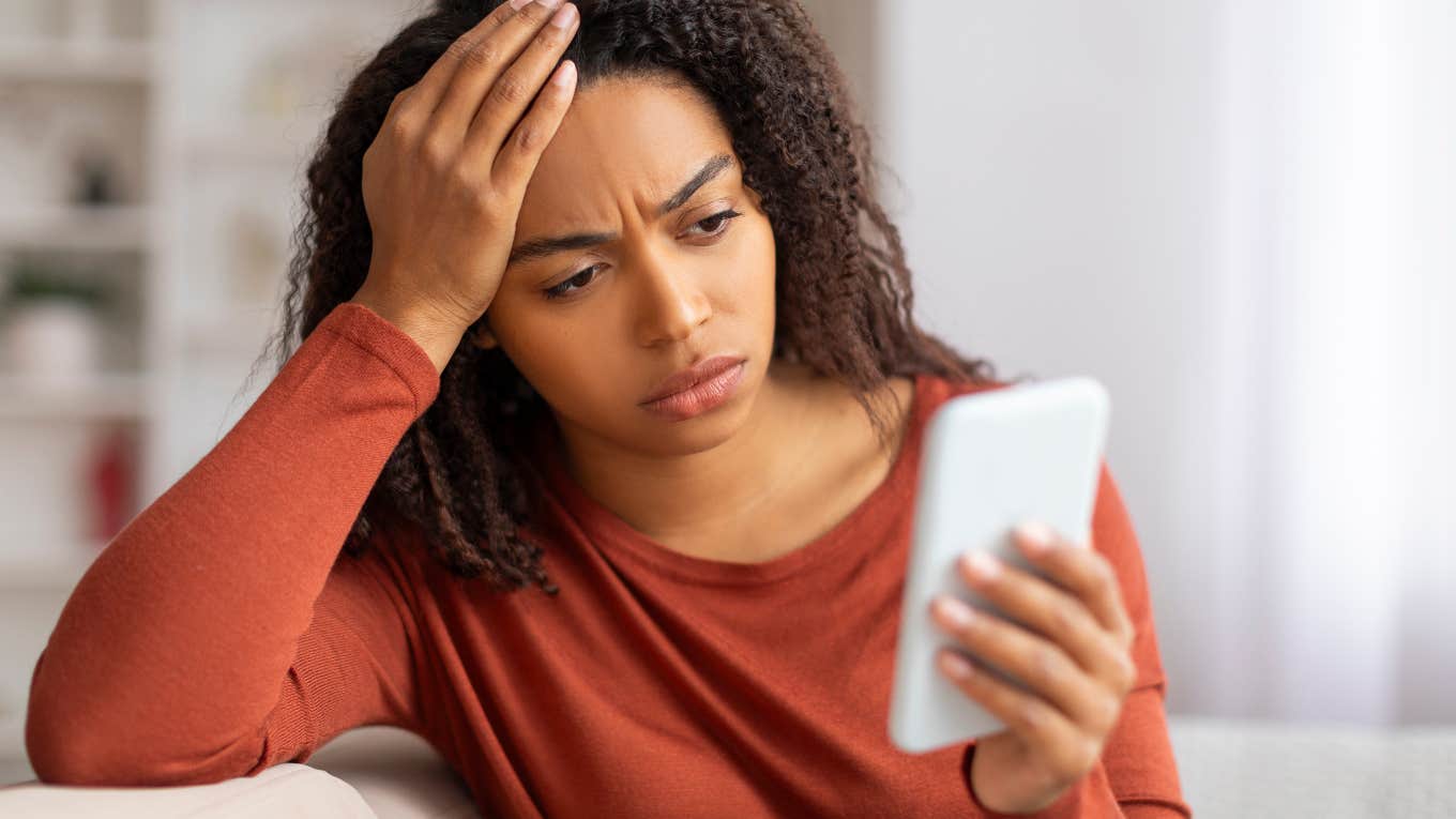 Concerned woman looking at the Economist’s 2025 World Ahead cover on her phone