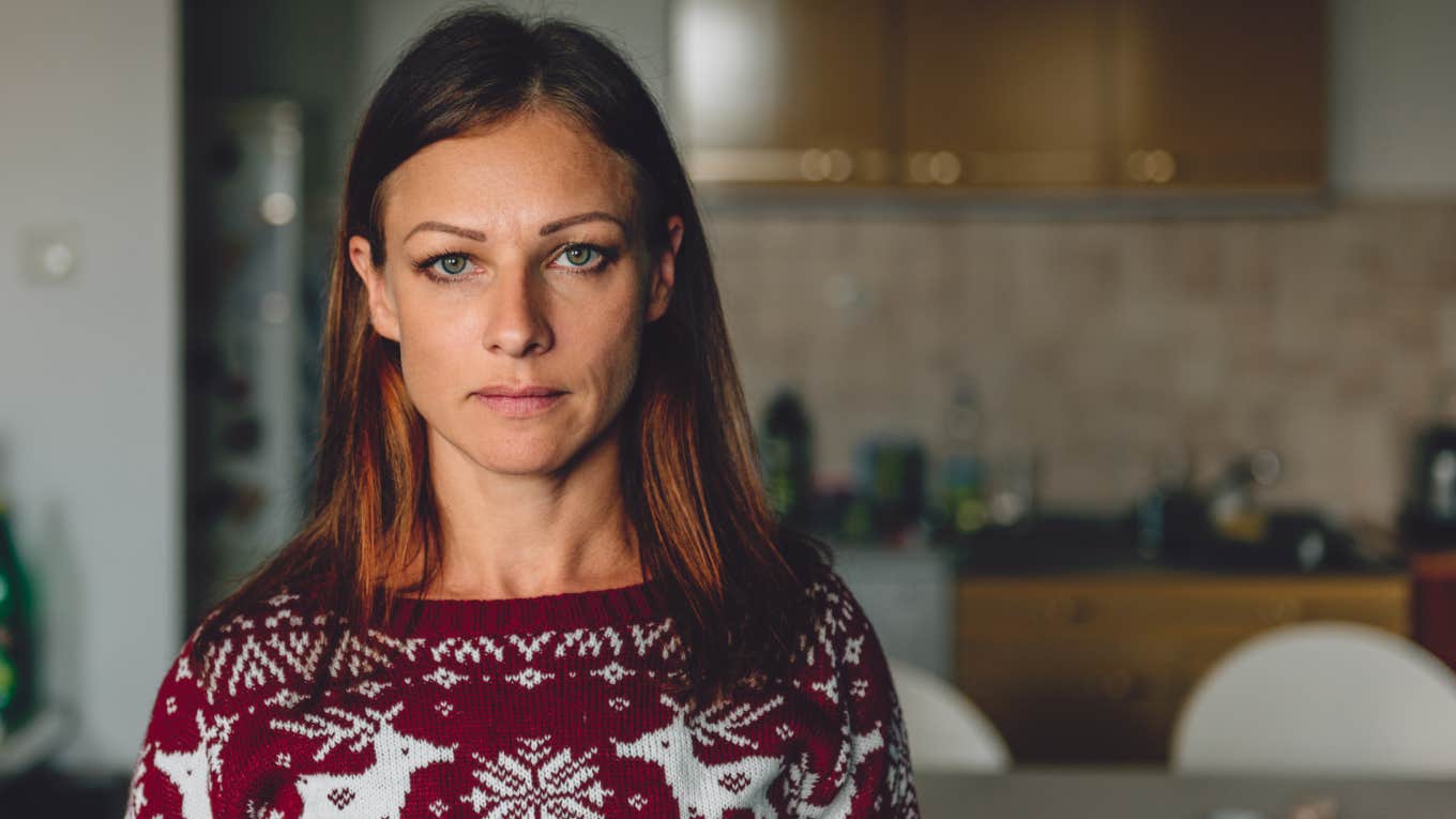 Portrait of woman standing in front of the kitchen wearing red sweater