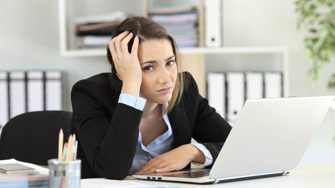 Woman sitting at desk after getting fired looking upset