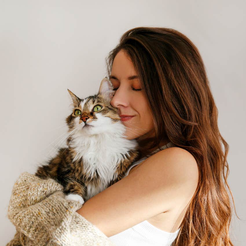 American woman hugging her cat