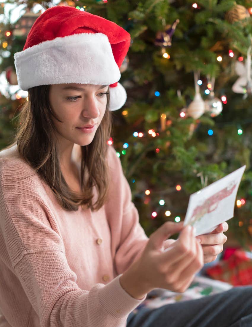 Unhappy woman reading a holiday card addressed to her husband