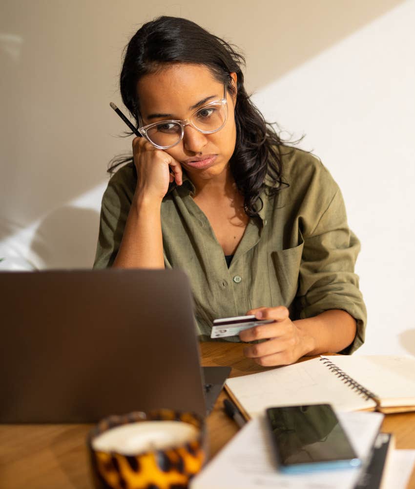 woman looking at credit card balance on laptop