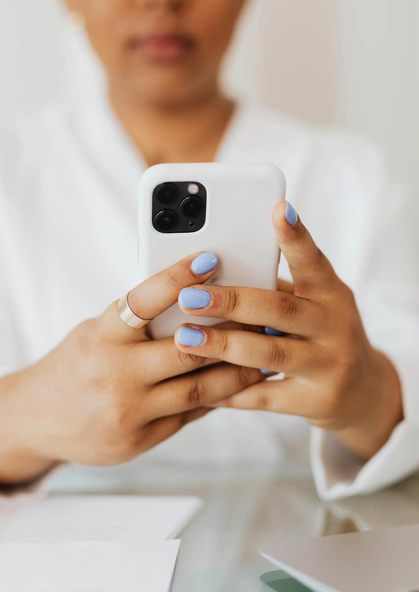 woman in white shirt texting on phone with white case