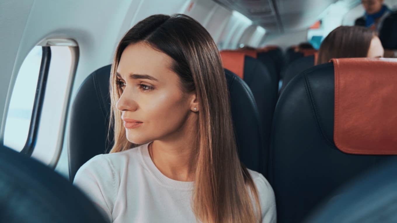 woman looking out window on plane 