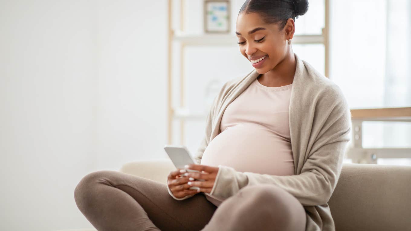 pregnant woman looking at her phone