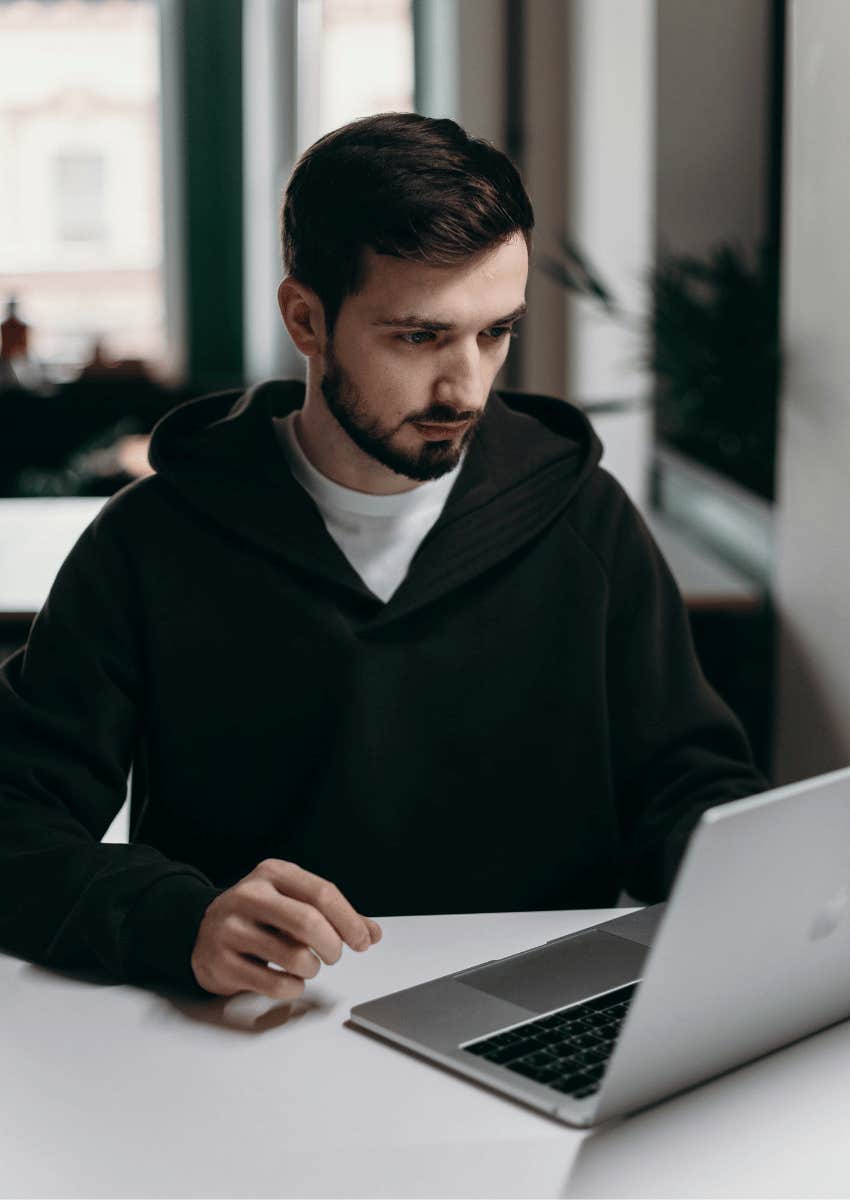 young man focused on an open laptop