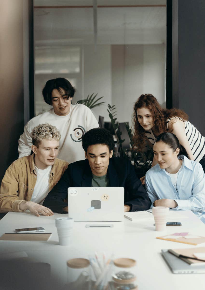 young people surrounding a laptop