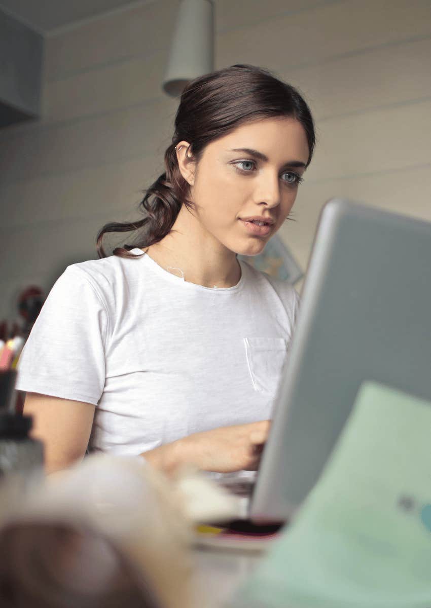 young woman focused on an open laptop