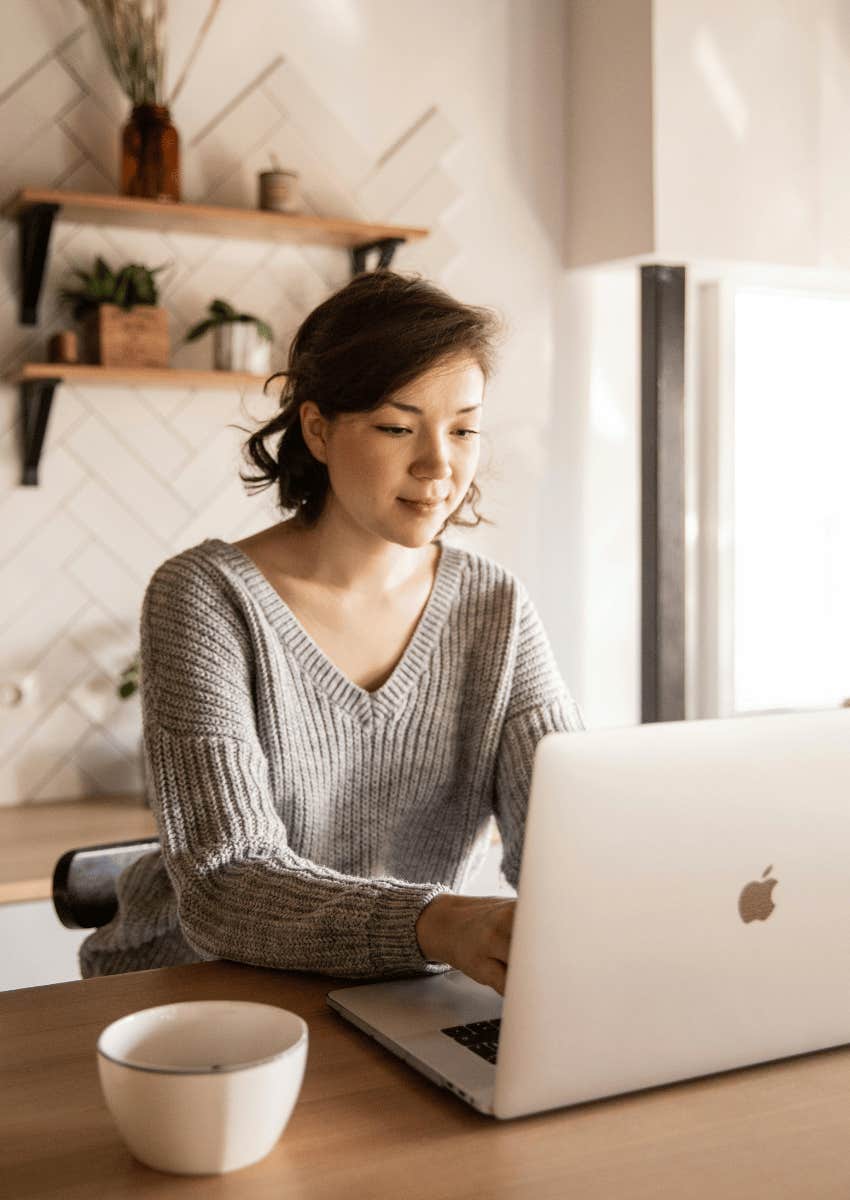 young woman focused on an open laptop