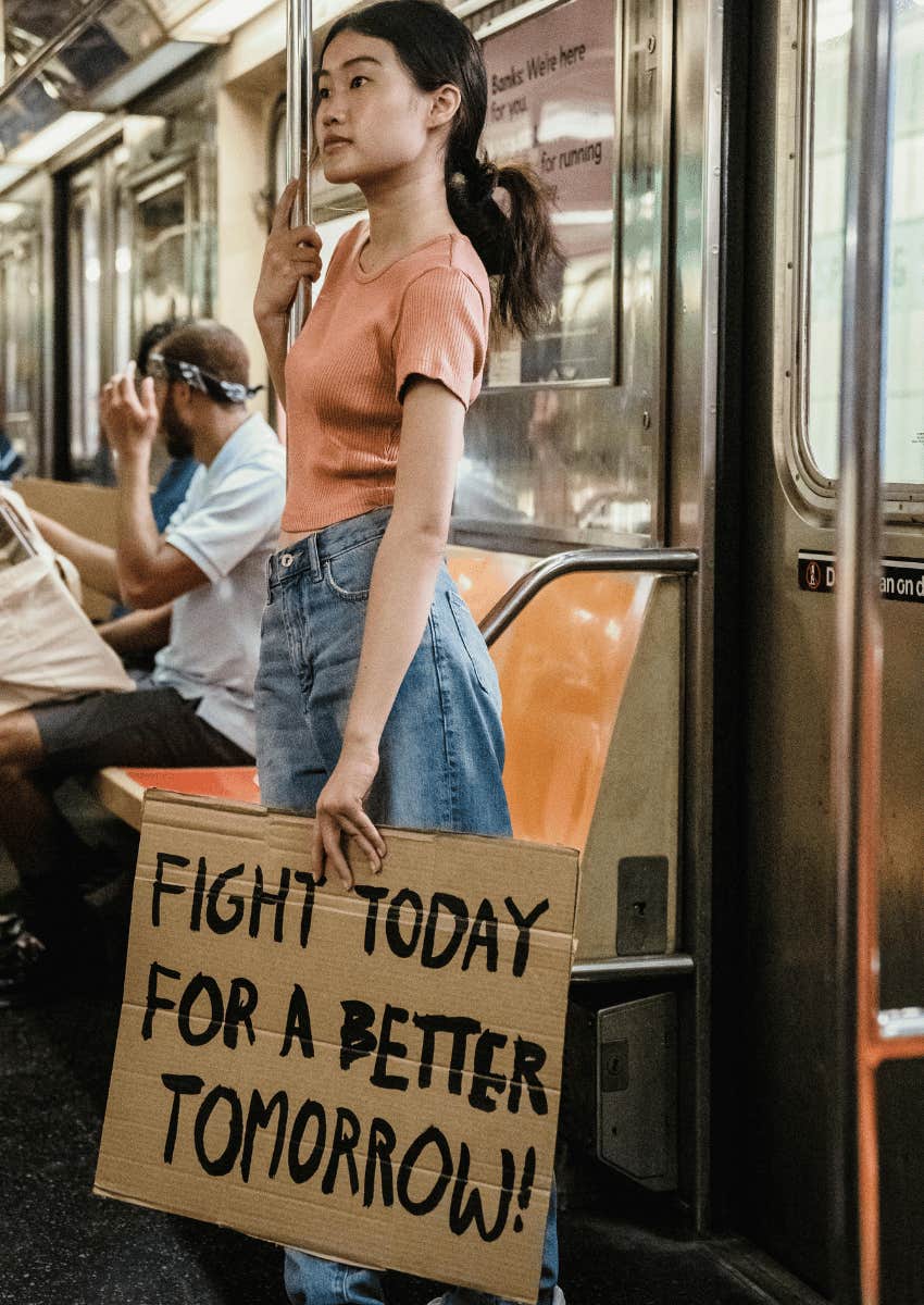 young woman holding an activist sign