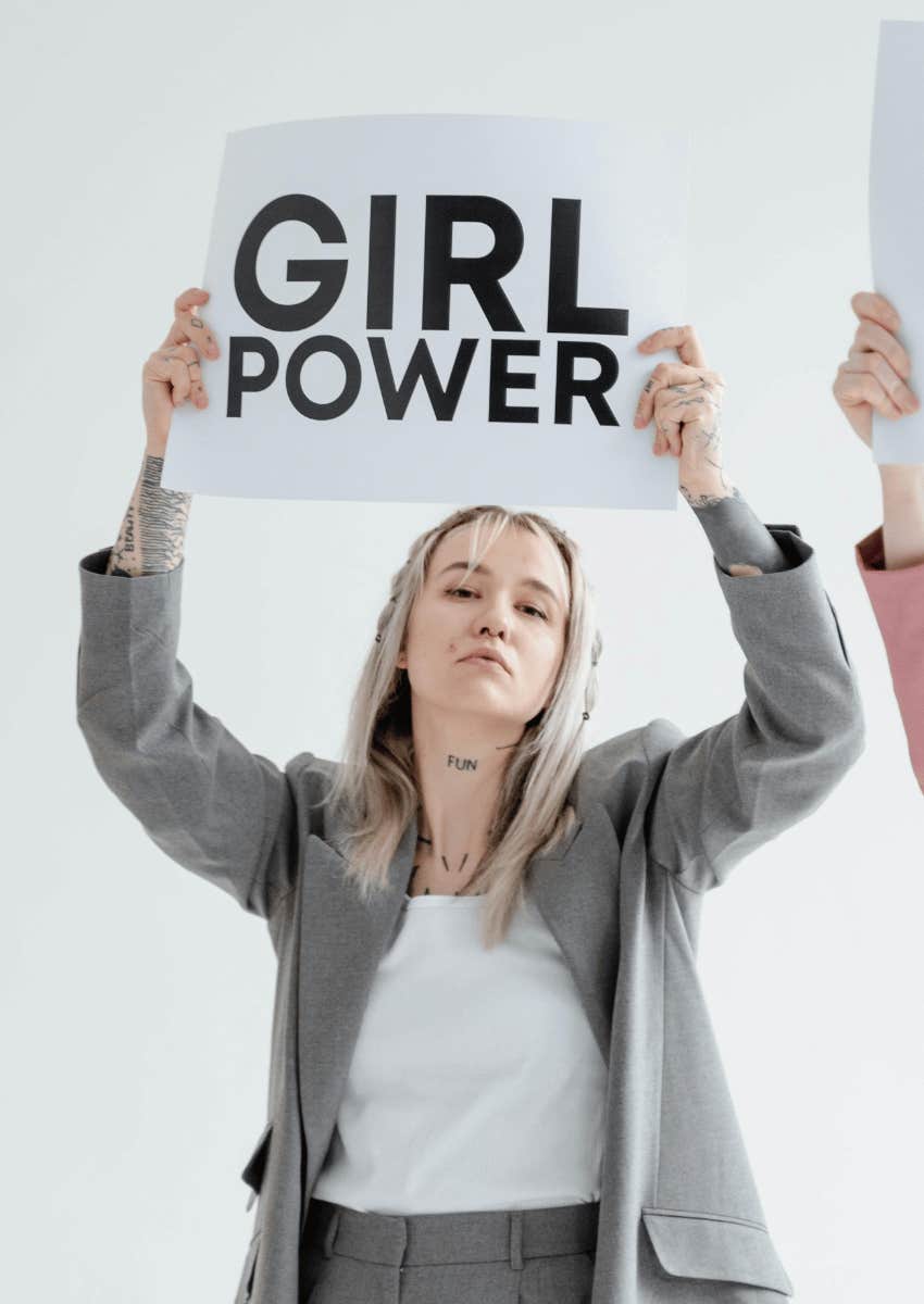 young woman holding a girl power sign