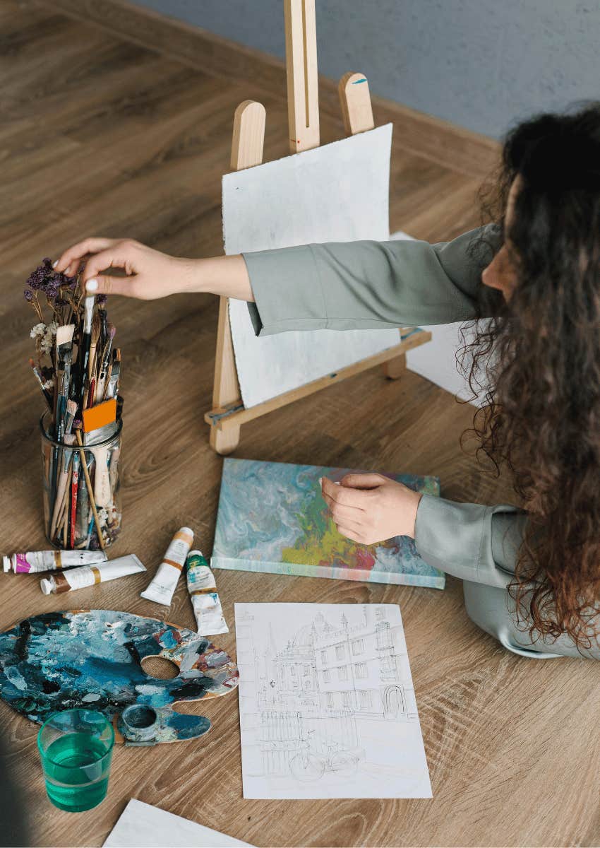 young woman painting on a canvas