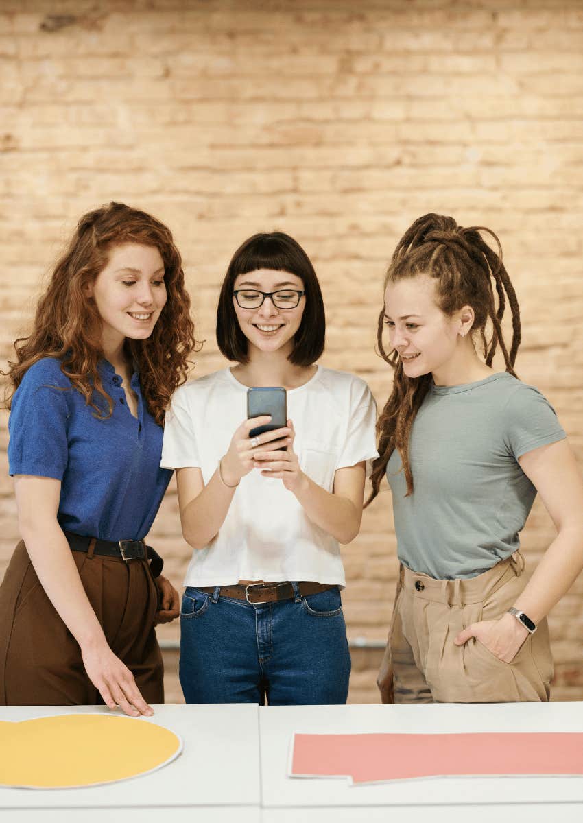 young women looking at a phone together