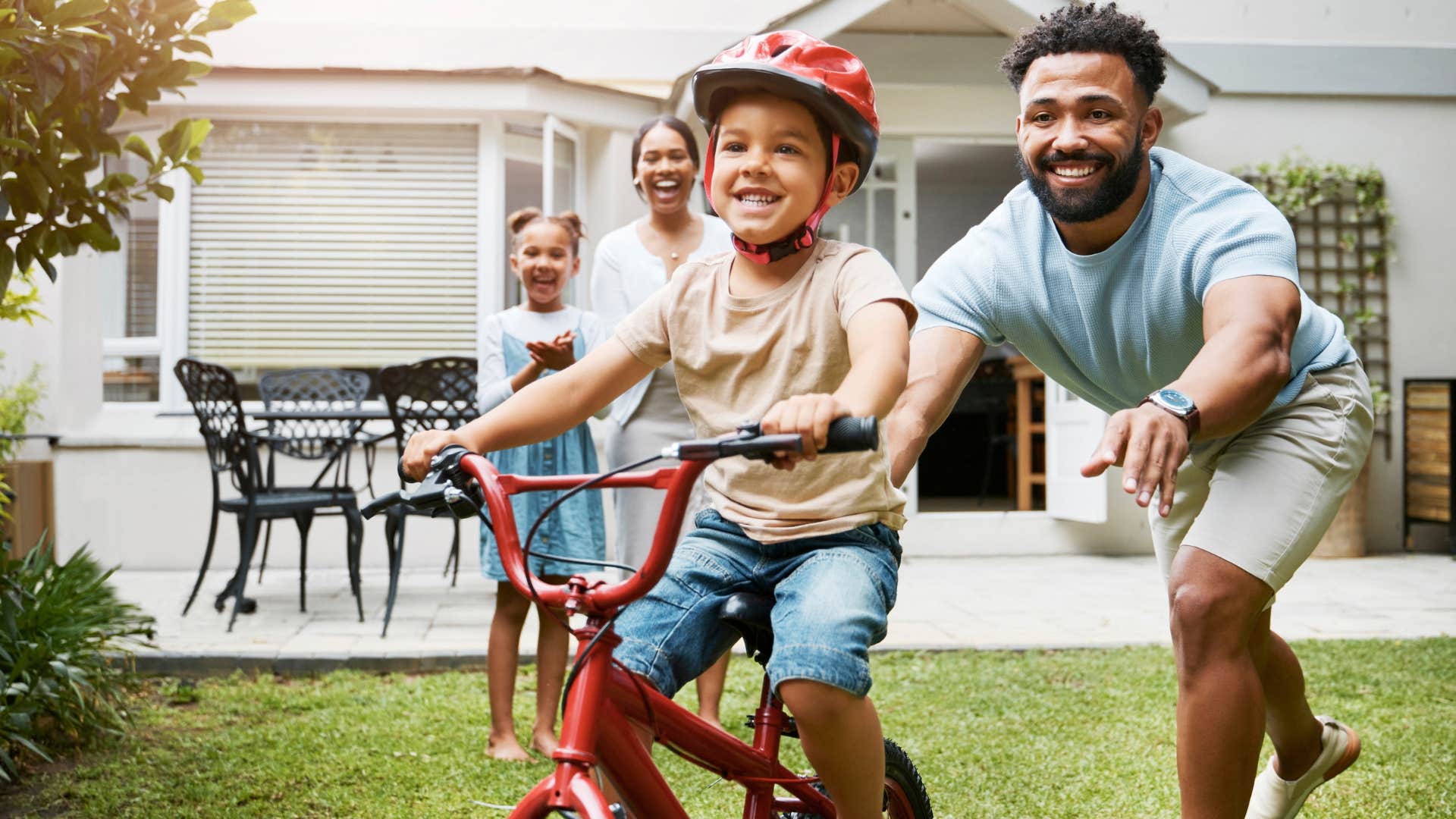 Man pushing his young son on his bicycle. 