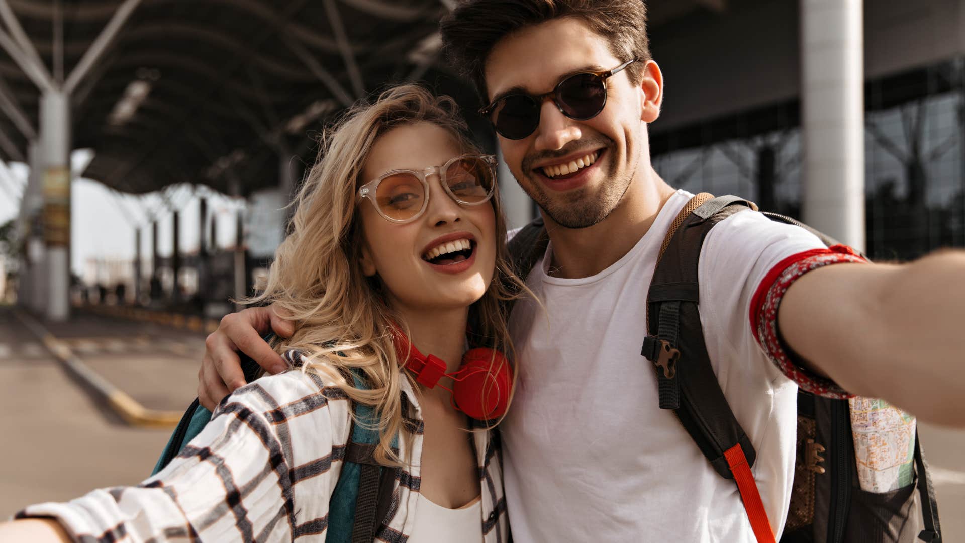 woman with red headphones hugs her guy friend