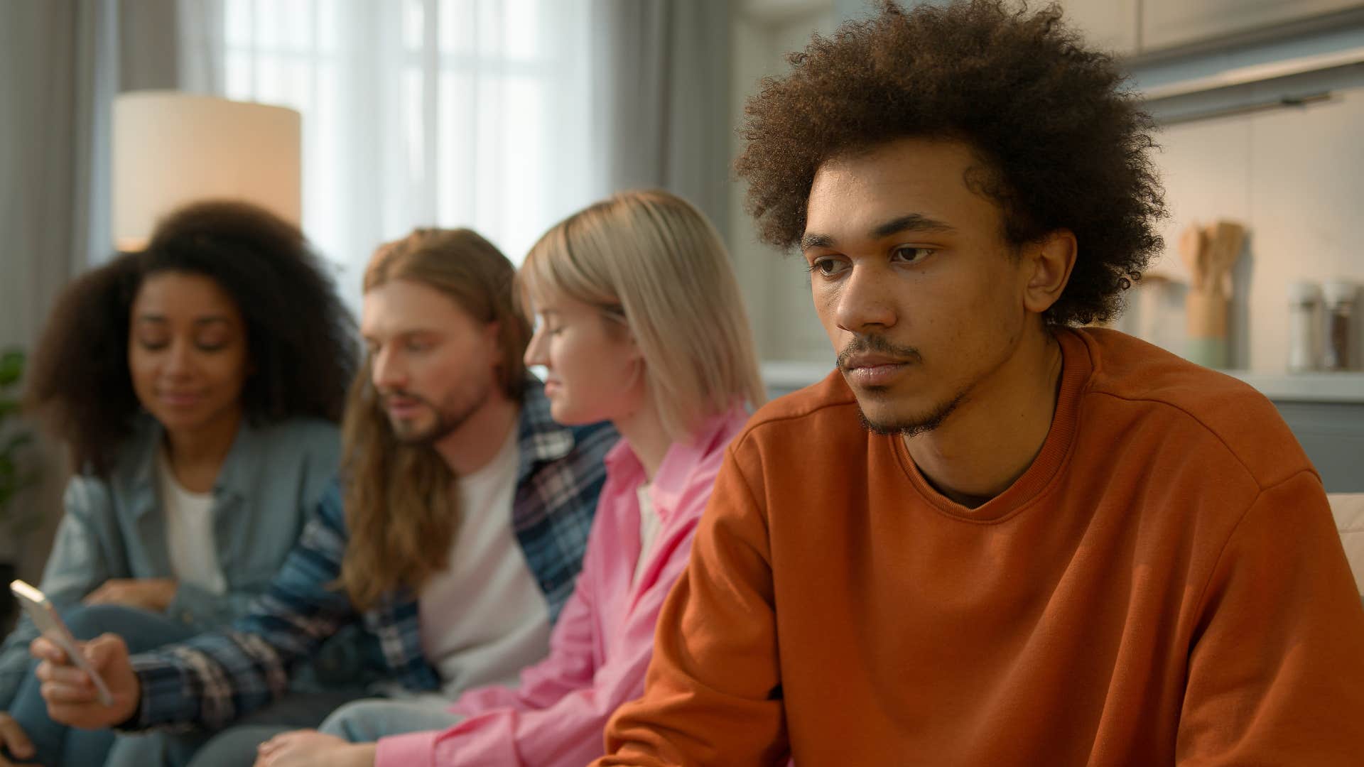 sad pensive man with friends in the background