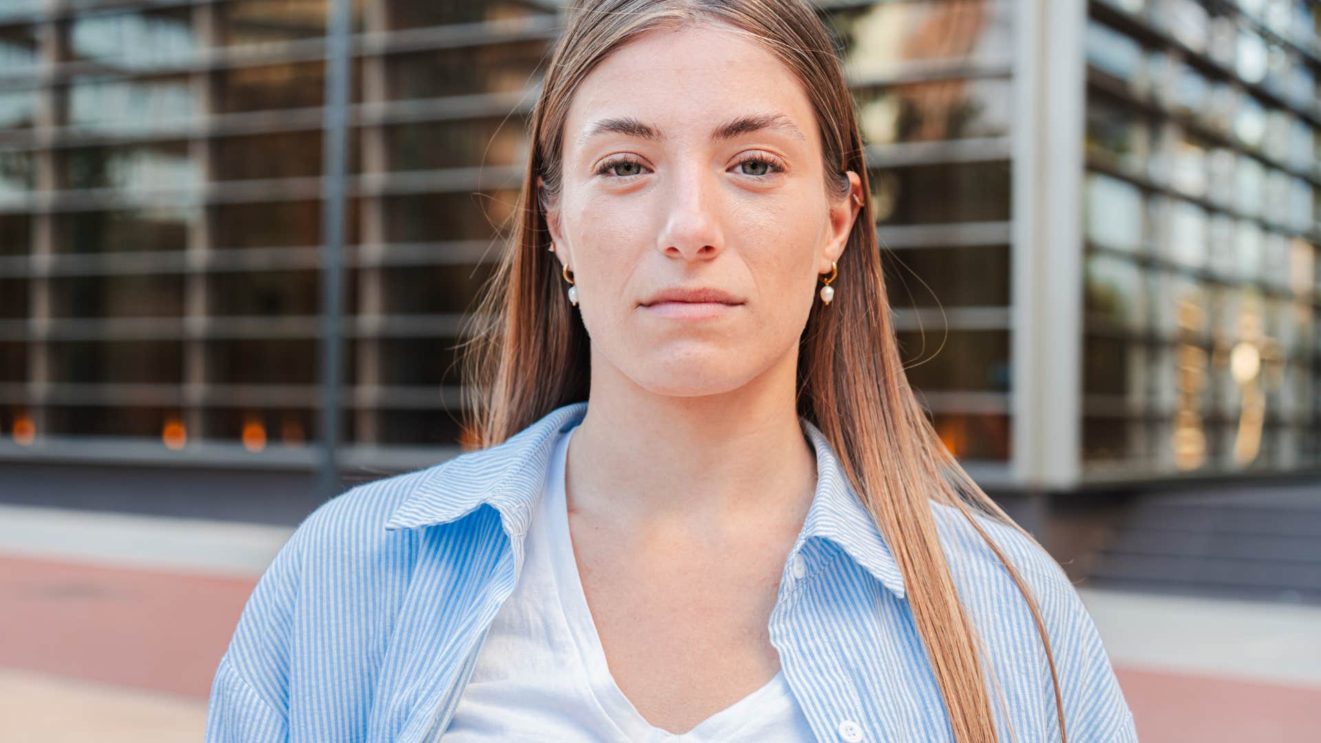 Close up individual portrait of a confident and formal teenage blonde woman with serious expression.