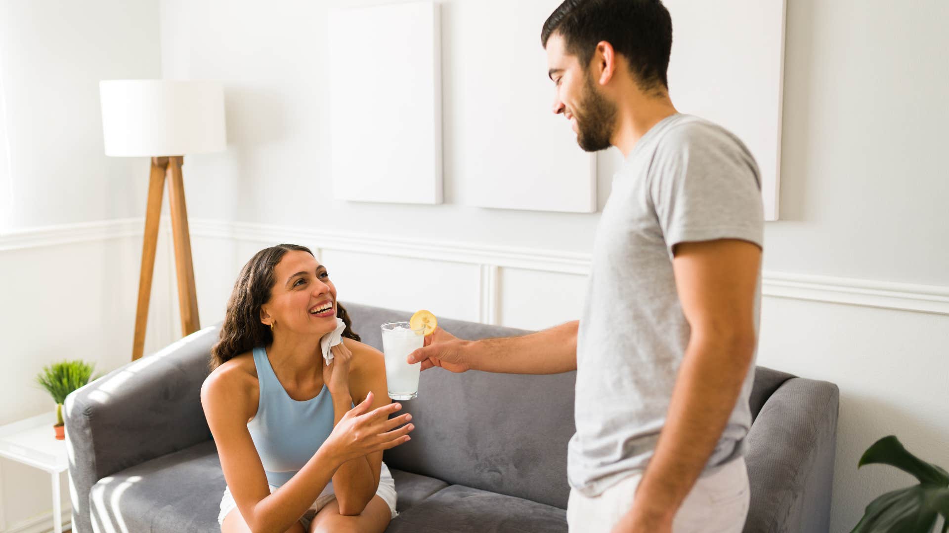 Husband giving his partner a cold beverage on a hot day