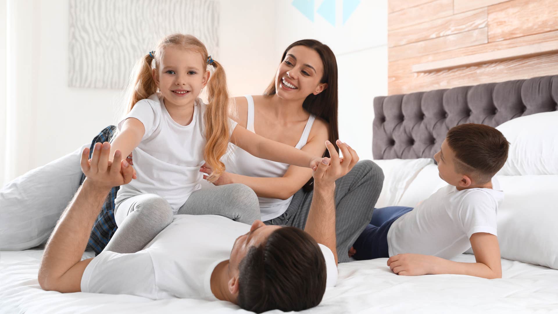 Couple and kids on king-size mattress